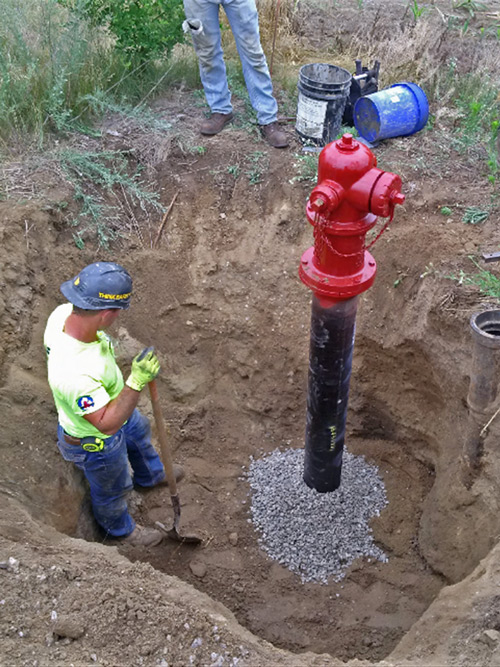 DE Excavating worker installing a fire hydrant in Sylvan Michigan